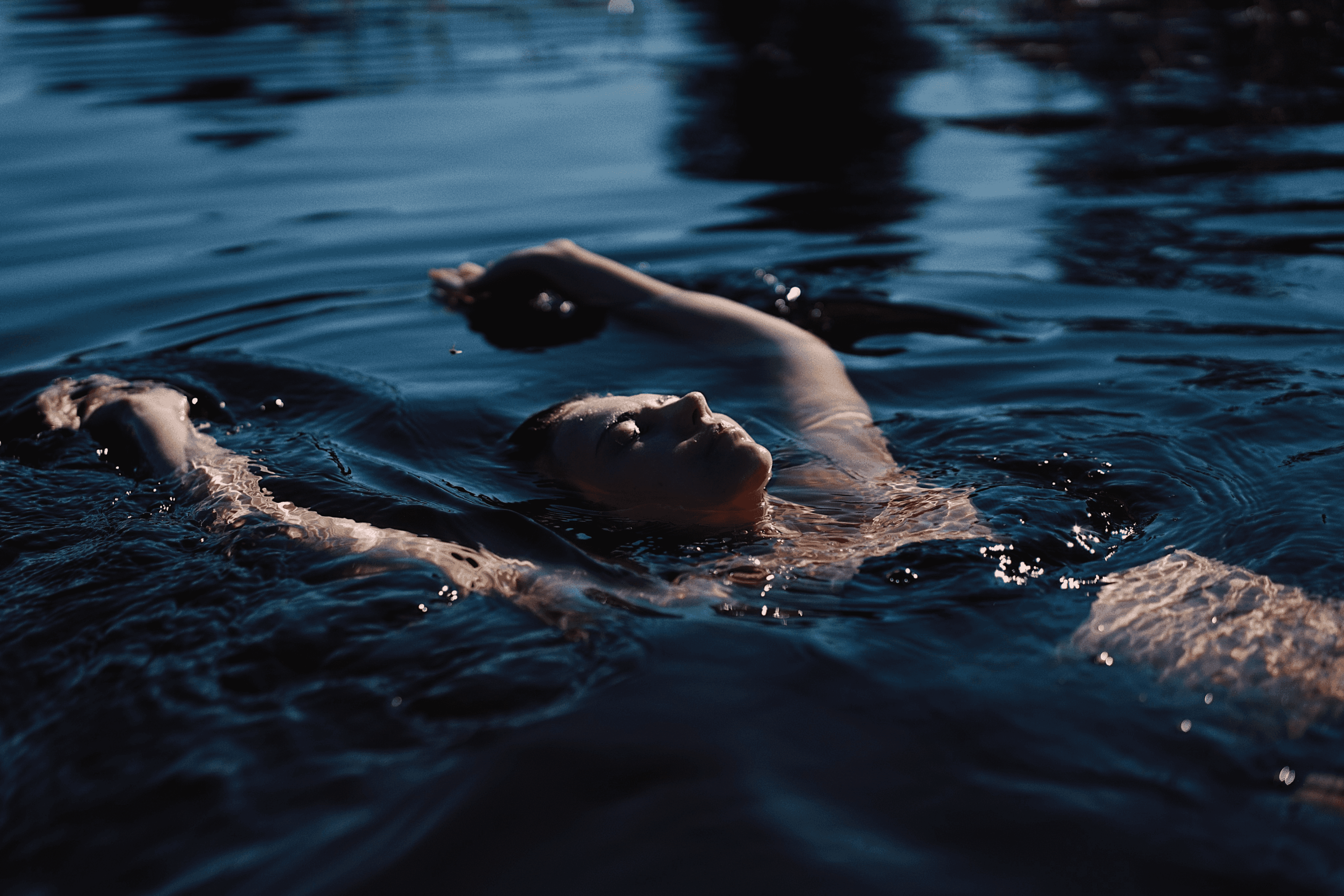 Woman relaxed wild swimming in natural surroundings