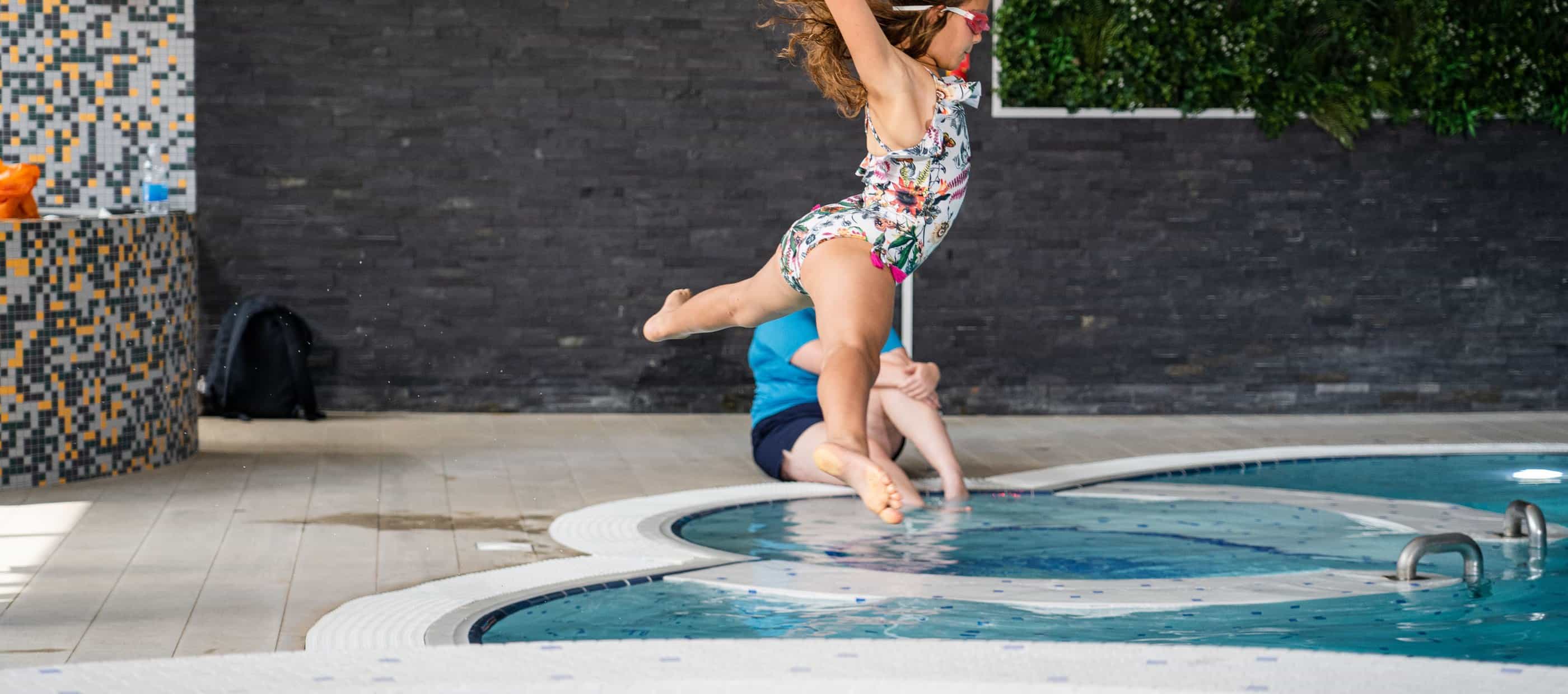 Child jumping into swimming pool