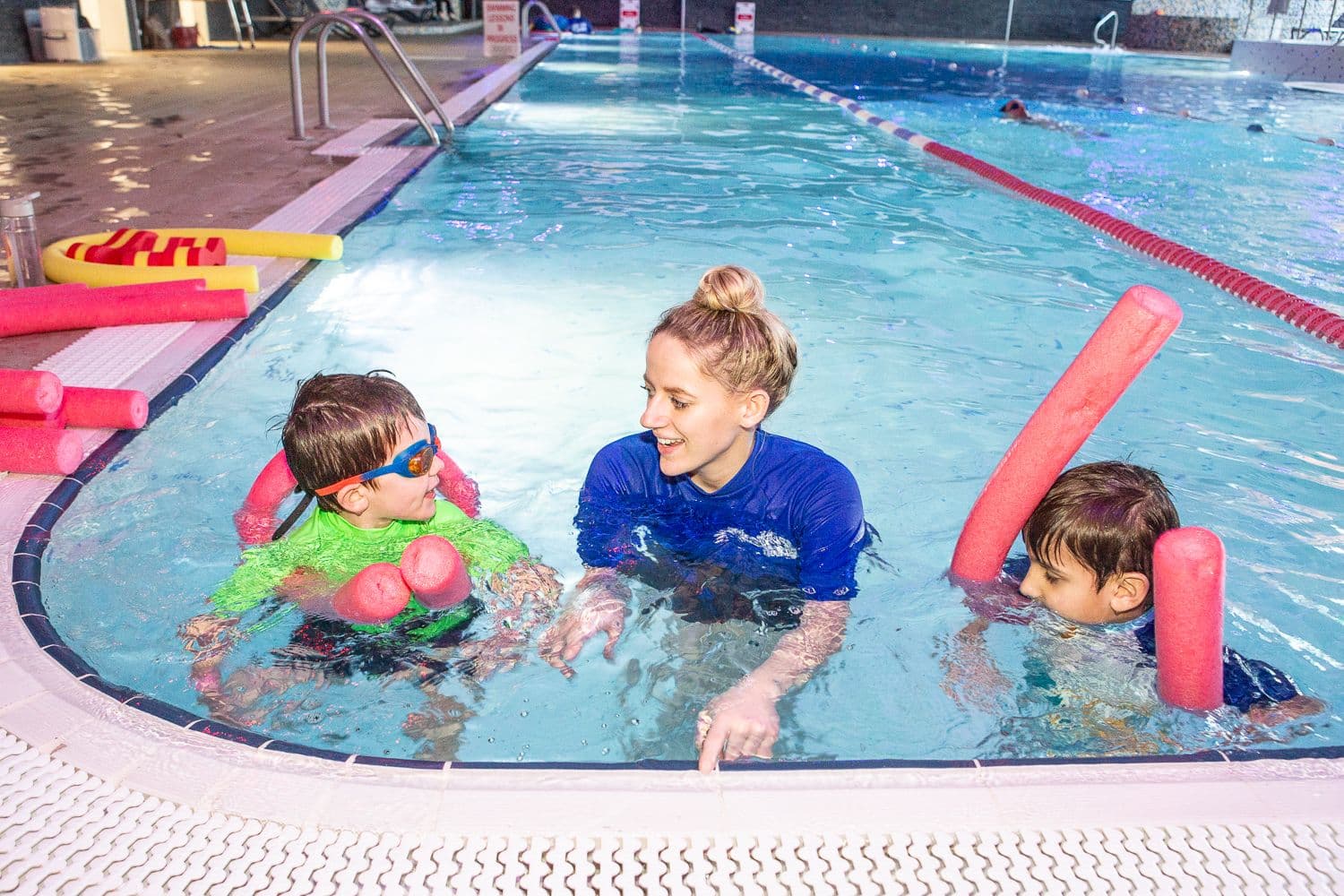 Swimming instructor teaching children in pool