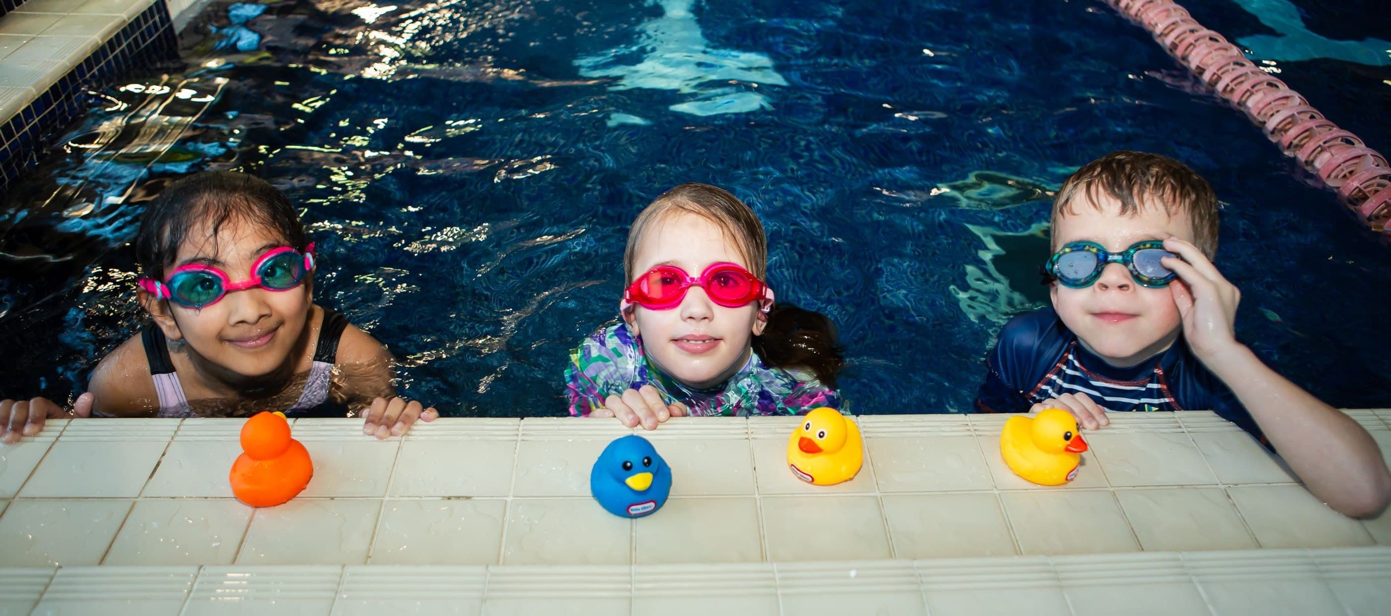 Children sitting on edge of pool 
