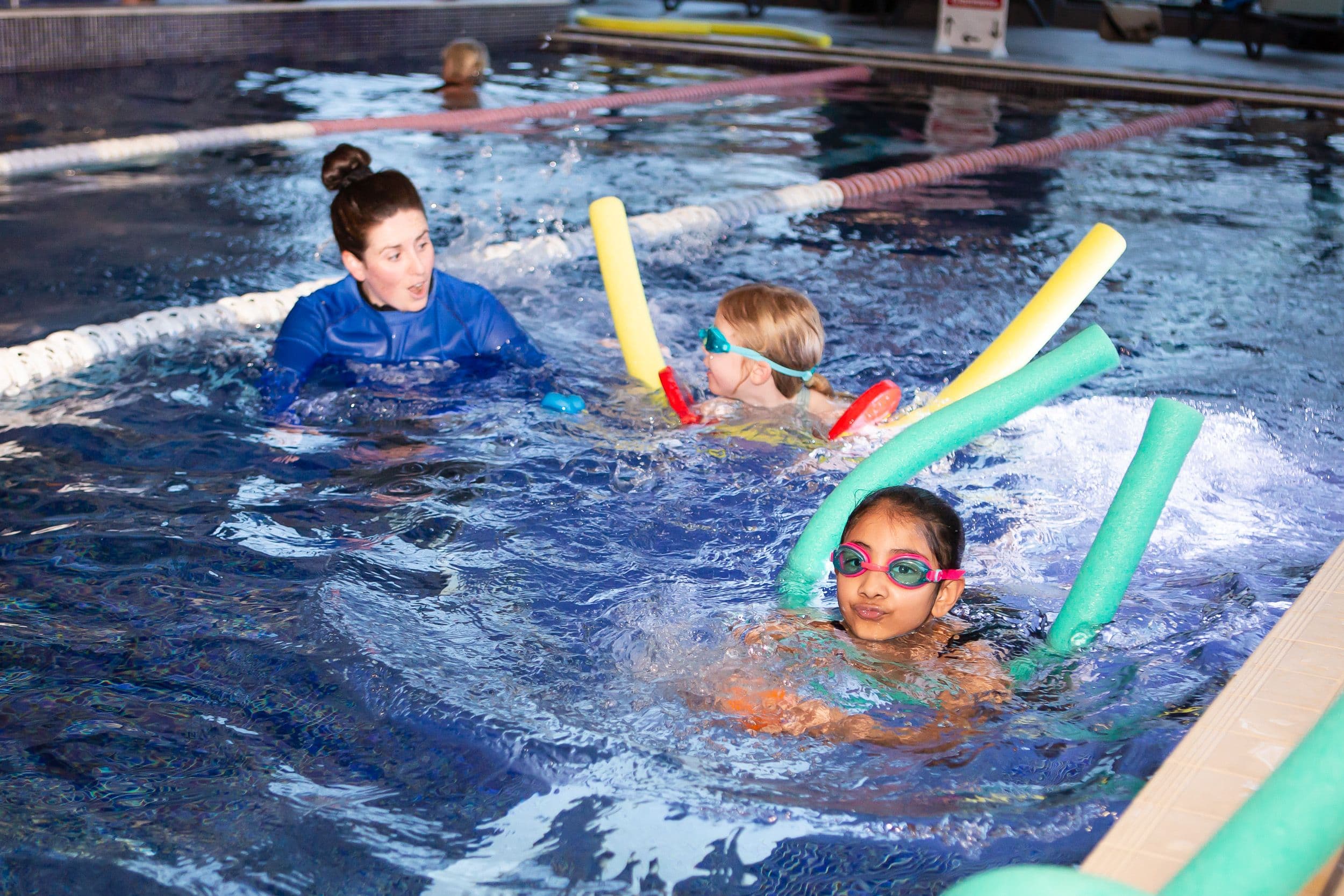 Children swimming in pool with floaties