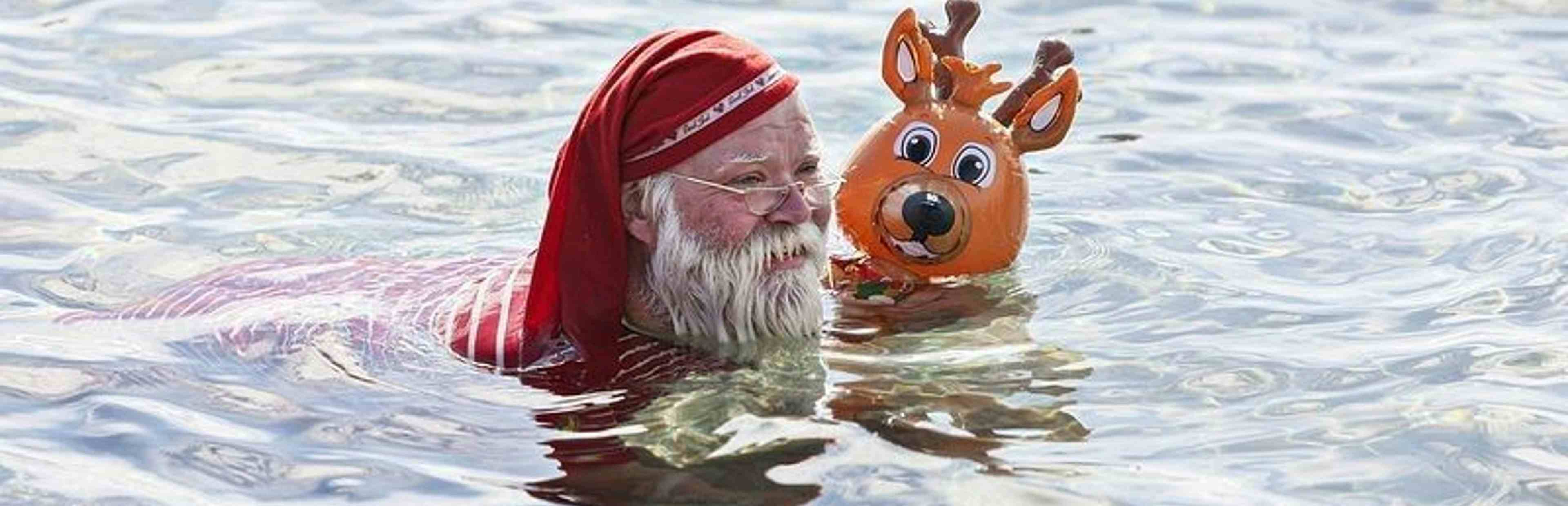 Santa swimming in lake with Reindeer 