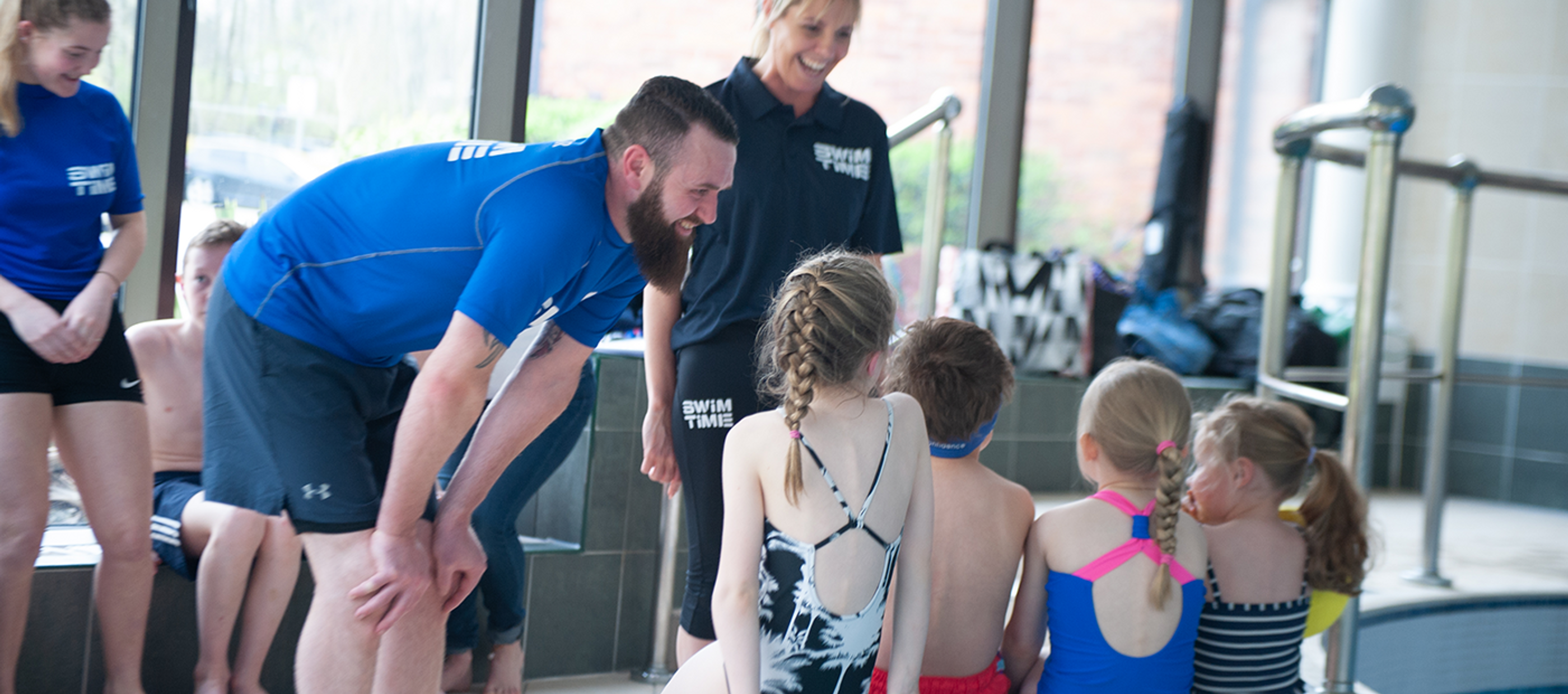 Swimming instructor talking to children