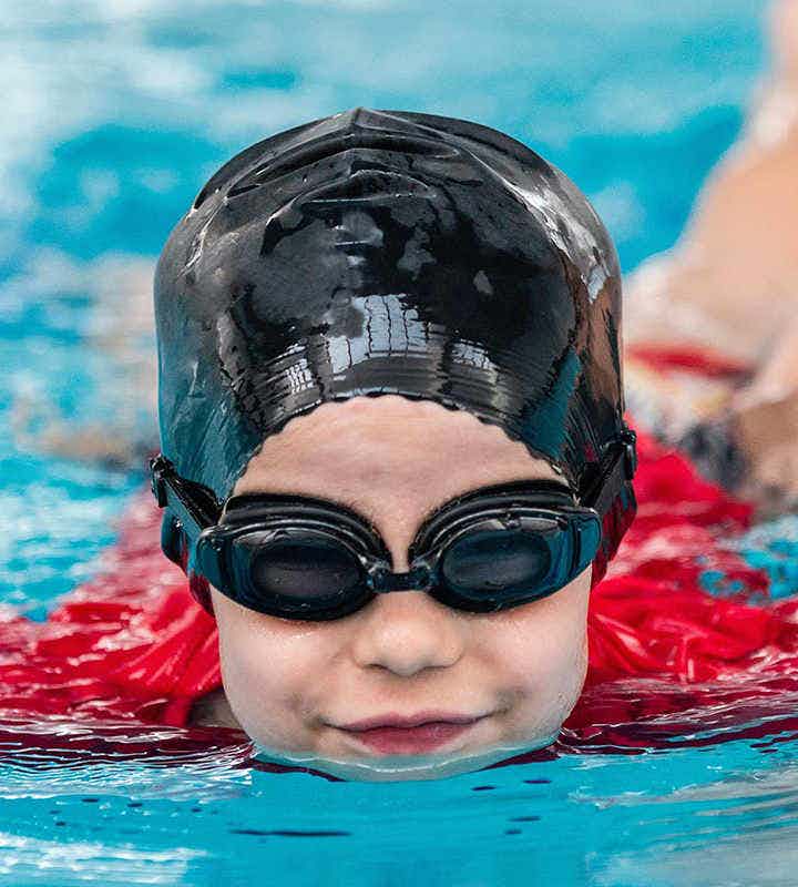 Child swimming and wearing a swimming cap