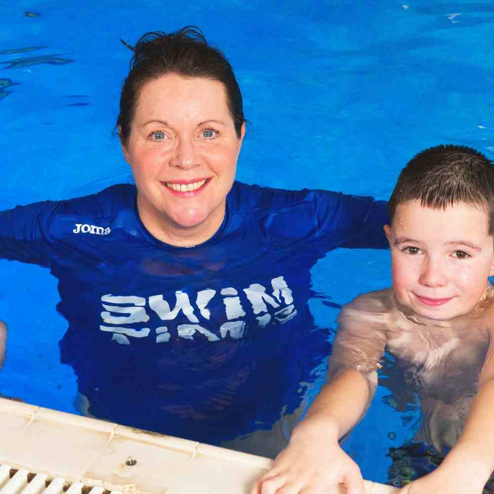 Swimming instructor and children in swimming pool