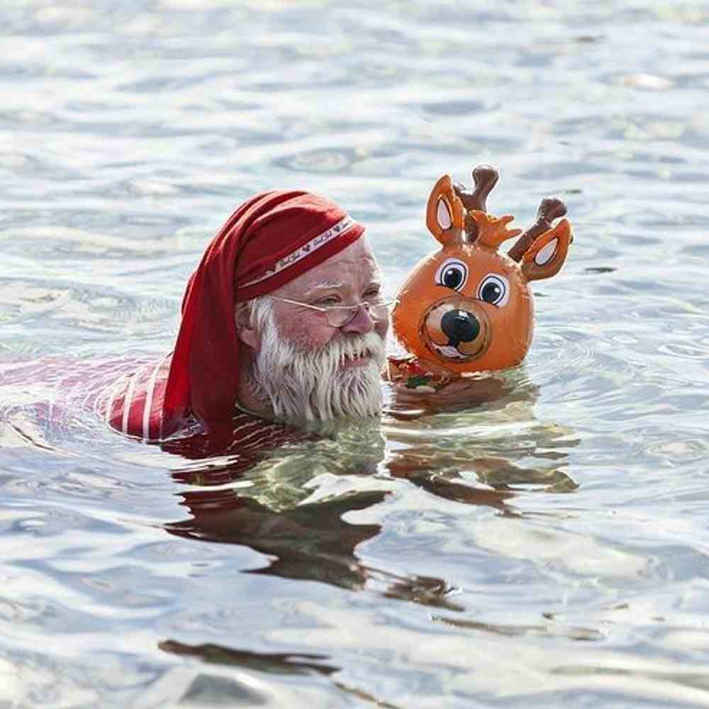 Santa swimming in lake with Reindeer 