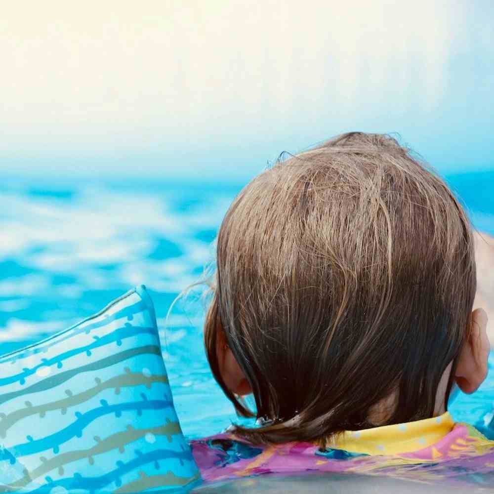 Child swimming and wearing floaties