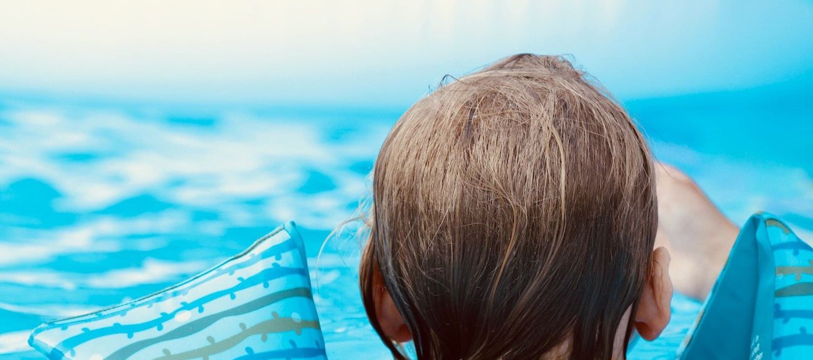 Child swimming and wearing floaties