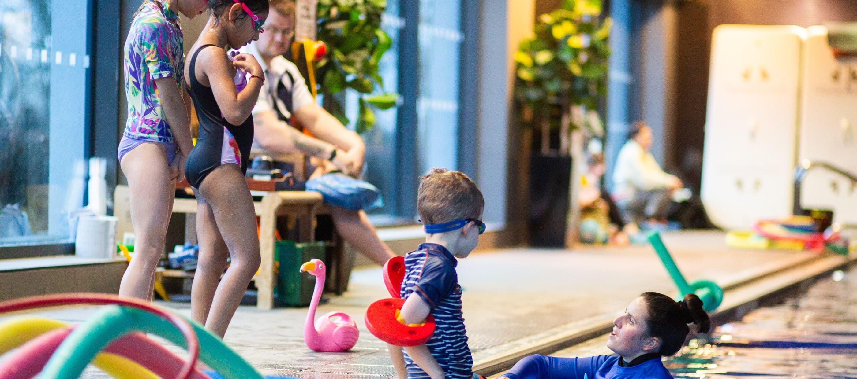 Child resting on side of pool